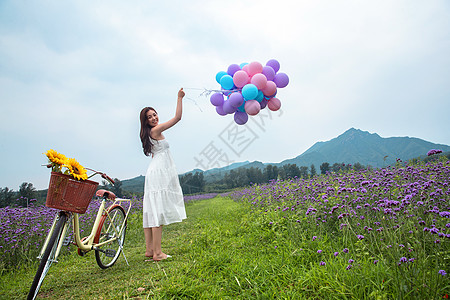 紫色美女青年女人在花海里拿着气球背景