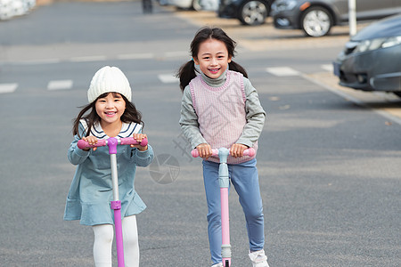 快乐的小女孩在户外玩滑板车图片