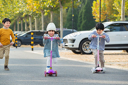 快乐的儿童在户外玩滑板车图片