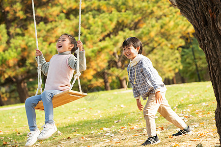 快乐儿童在公园里荡秋千图片