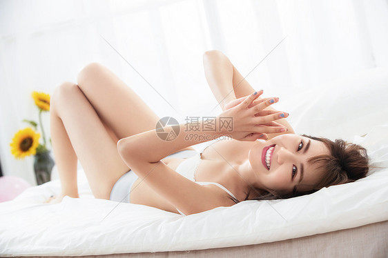 年轻女人躺在床上图片