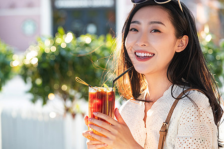 墨镜美女快乐的青年女人品尝夏日饮品背景