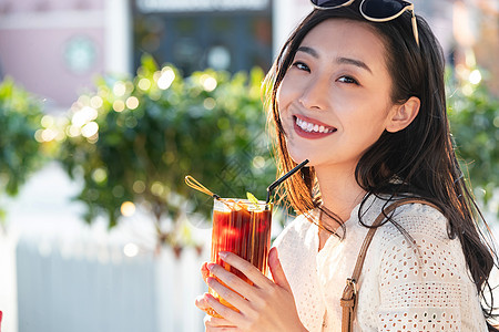 快乐的青年女人拿着夏日饮品图片