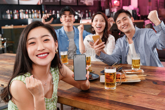 青年朋友在酒吧喝酒玩手机图片