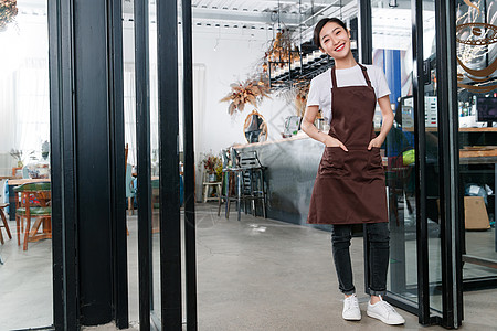 餐饮服务站在咖啡店门口的女服务员背景