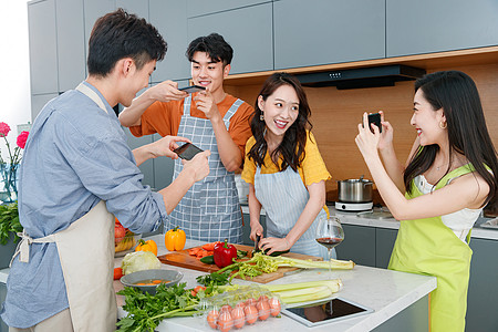 快乐的年轻人在厨房做饭照相图片