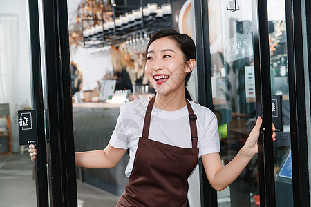 咖啡店门口迎接顾客的女服务员图片