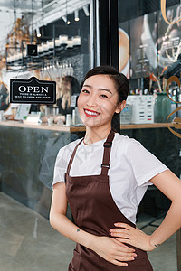 咖啡店门口迎接顾客的女服务员高清图片