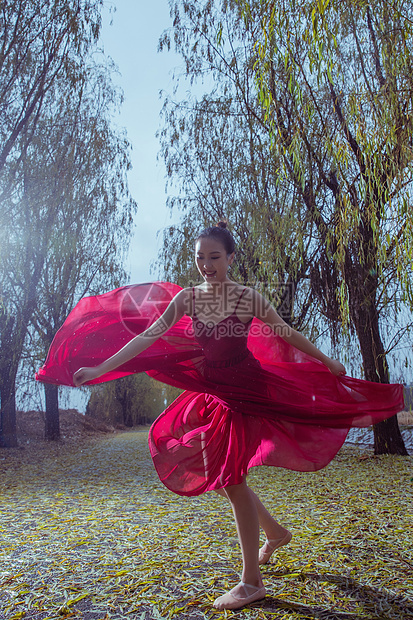 穿红色裙子的青年女人在户外跳芭蕾舞图片