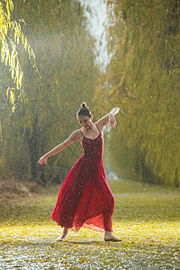 穿红色裙子的青年女人在户外跳芭蕾舞图片