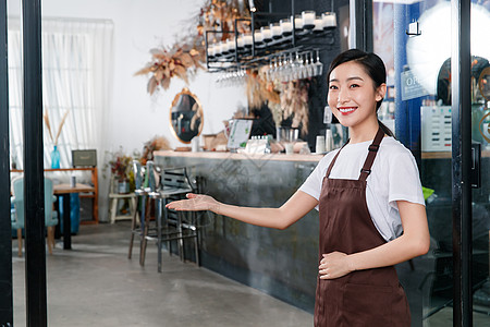 咖啡店门口迎接顾客的女服务员图片