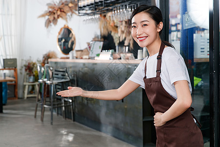咖啡店门口迎接顾客的女服务员图片