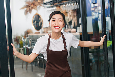 咖啡店门口迎接顾客的女服务员图片