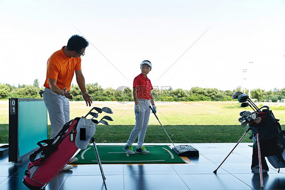 练习场上教练指导儿童打高尔夫图片