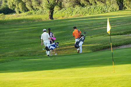 老人高尔夫高尔夫球场上青年人和老年人一起步行的背影背景