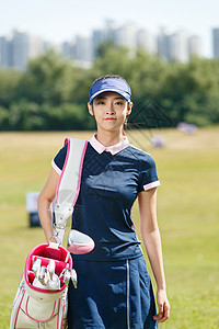 快乐的青年女人背着高尔夫球包高清图片