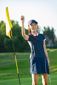 举着旗帜的女孩举着高尔夫球的青年女人背景