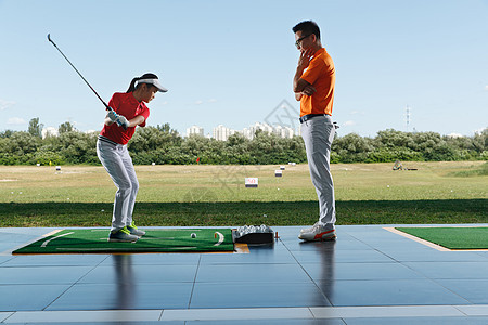 练习场上教练指导女童打高尔夫图片