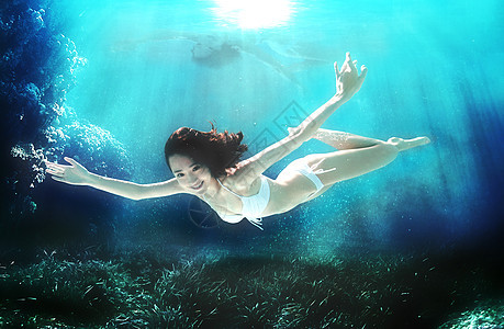 年轻女人在水下游泳图片
