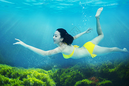 在水中游泳的人年轻女人在水下游泳背景