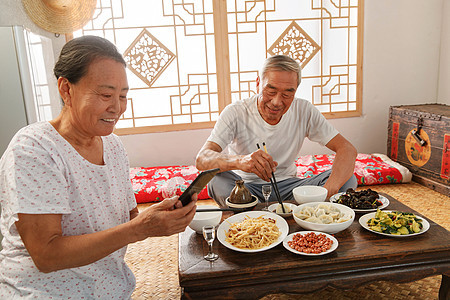 老年夫妇在家里吃饭看手机图片