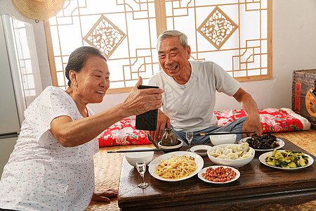 老年夫妇在家里吃饭看手机高清图片