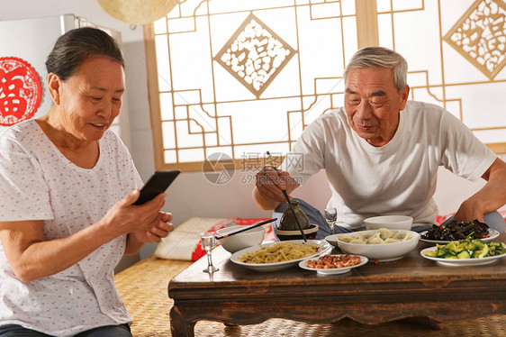 老年夫妇在家里吃饭看手机图片