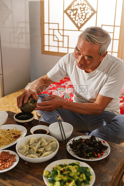老年人坐在家里吃饭喝酒图片