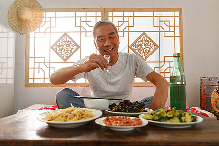 老年人坐在家里吃饭喝酒图片