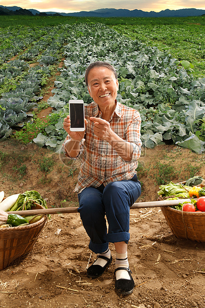 坐在田头的农民拿着手机图片