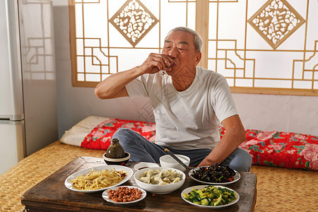 老年人坐在家里喝酒吃饭图片