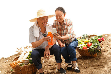 农民夫妇坐在田头看手机图片