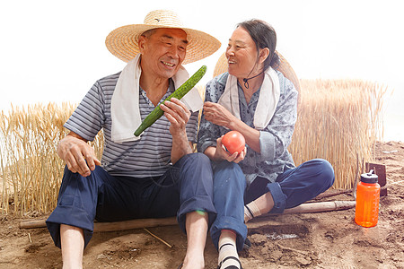 农民夫妇坐在农田里吃东西图片