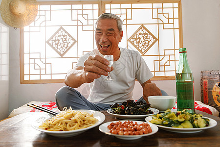 老年人坐在家里喝酒吃饭图片