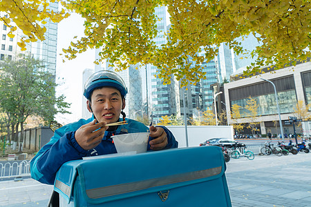 外卖员在街道旁吃饭休息图片