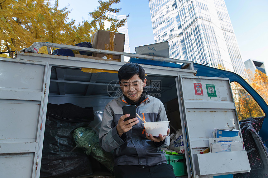 快递员坐在快递车上休息图片