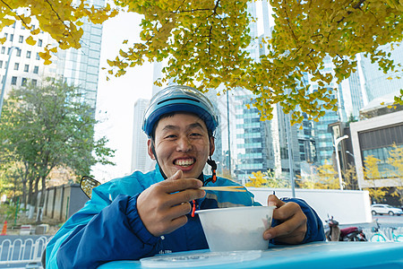 外卖员在街道旁吃饭休息高清图片