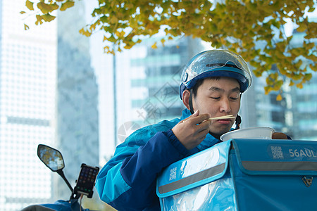 外卖员在街道旁吃饭休息图片