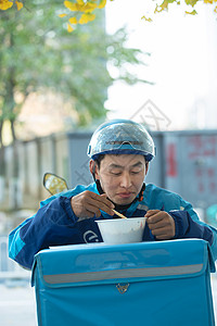 外卖员在街道旁吃饭休息图片