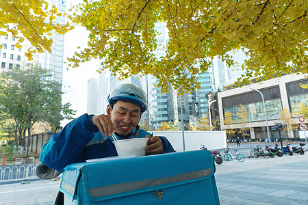 外卖员在街道旁吃饭休息图片