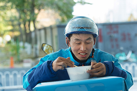 外卖员在街道旁吃饭休息图片