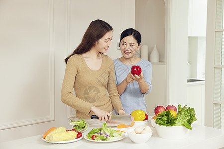 母亲指导女儿烹饪菜肴图片