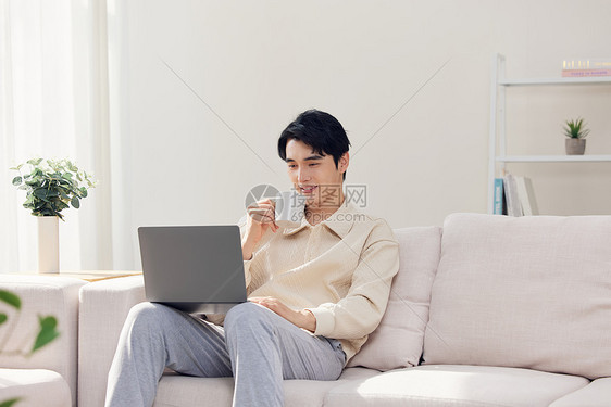 居家男性看电脑喝茶图片