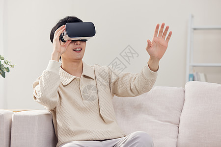 居家男性戴vr眼镜操作虚拟屏幕背景图片