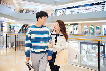 商场里开心购物的热恋情侣背景图片
