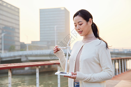 国际教育青年女性手拿太阳能风车模型背景