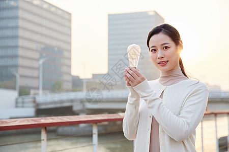 美丽地球户外手拿节能电灯泡的女性背景