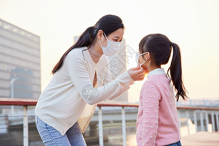 户外妈妈帮女儿戴口罩图片