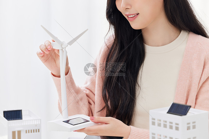 手拿风力发电模型的青年女子图片