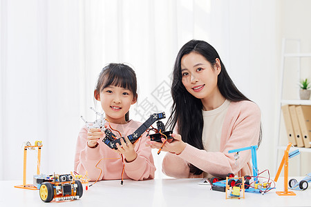科技教育手拿机器人的小女孩与女老师背景